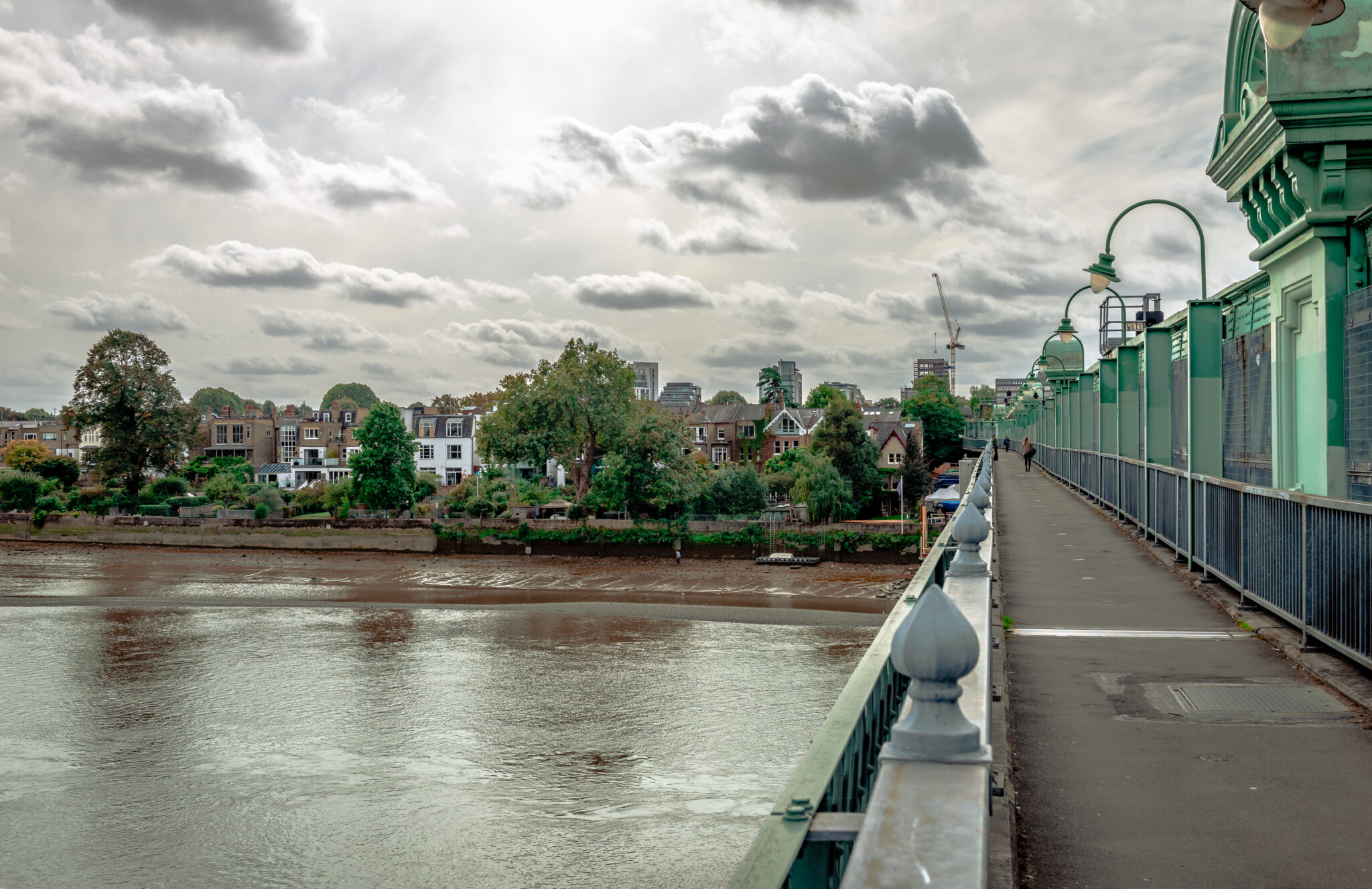 The Fulham Railway Bridge that spans the river Thames, seen from the north. Colloquially known as The Iron Bridge, it can also be crossed on foot. Putney is in the background.